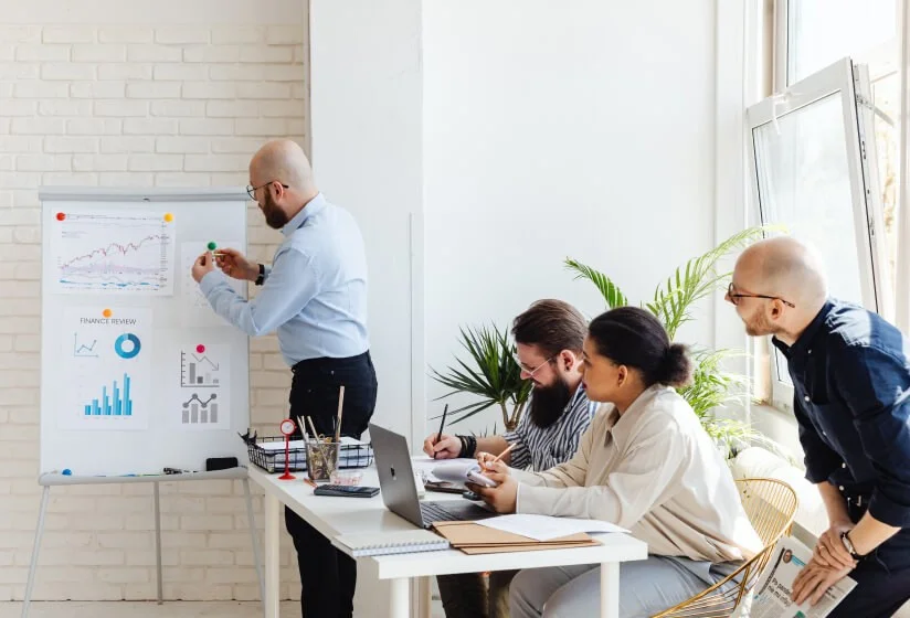 A nonprofit team reviewing data and plans together in a meeting, representing budget-conscious compliance and security training planning.